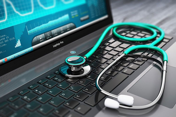 A stethoscope laying on top of a laptop keyboard